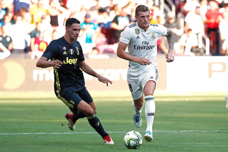 Real Madrid's Toni Kroos dribbles the ball as Juventus' Mattia De Sciglio chases. Reuters