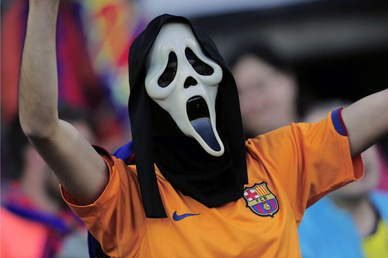 A supporter of Barcelona wearing a mask waits for the start of the UEFA Champions League semi-final second leg football match FC Barcelona vs FC Bayern Munich at the Camp Nou stadium in Barcelona on May 1, 2013.  TOPSHOTS/AFP PHOTO / JOSEP LAGO
 *** Local Caption ***  029735-01-08.jpg