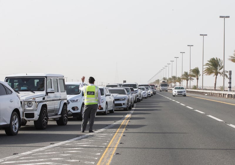 Dubai, United Arab Emirates - An officer controlling the queue to avoid traffic at the new  DPI Testing Centres border of Dubai and Abu Dhabi.  Leslie Pableo for The National for Shireena Al Nowais story