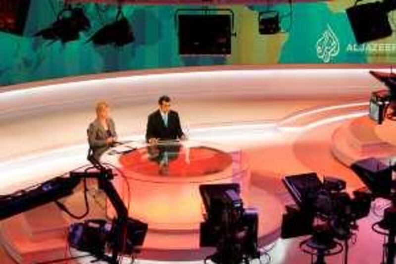 Newscasters work at the English-language newsroom at the headquarters of the Qatar-based Al Jazeera satellite channel in Doha November, 14, 2006. Arabic television station Al Jazeera launches an English-speaking channel on Wednesday to report world news from a Middle East perspective and challenge the dominance of Western media.   REUTERS/Mohammed Dubbous (QATAR)