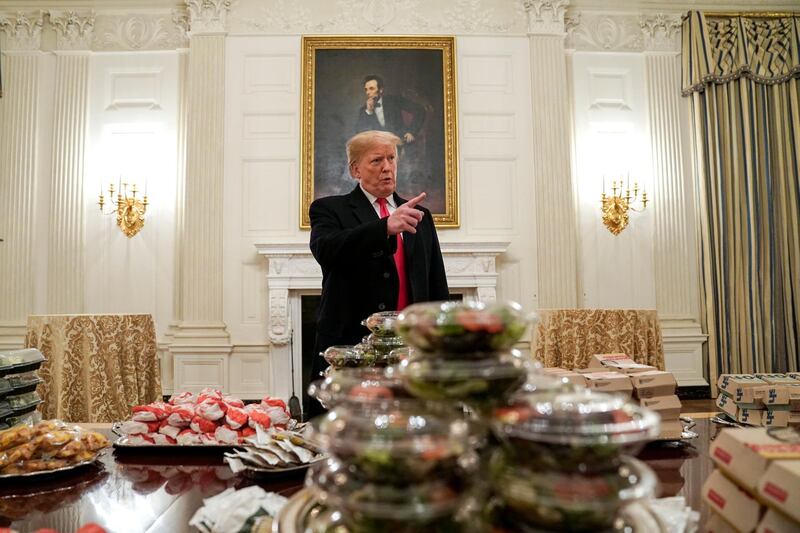 US President Donald Trump speaks in front of fast food provided for the 2018 College Football Playoff National Champion Clemson Tigers. Reuters