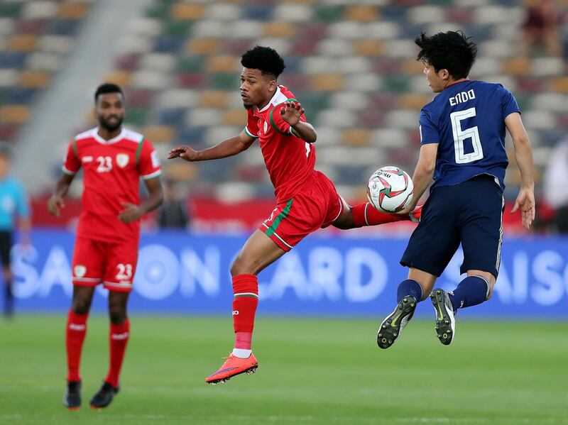 Abu Dhabi, United Arab Emirates - January 13, 2019: Endo Wataru of Japan and Jameel Al Yahmadi of Oman battle during the game between Japan and Oman in the Asian Cup 2019. Sunday, January 13th, 2019 at Zayed Sports City Stadium, Abu Dhabi. Chris Whiteoak/The National