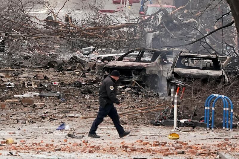 A law enforcement member walks past damage from an explosion in downtown Nashville. AP Photo