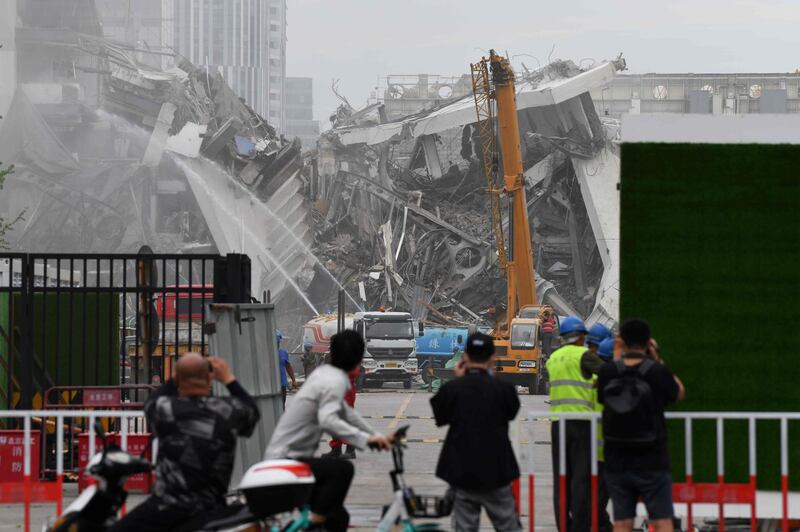 People gather to watch the demolition of the Workers' Stadium. AFP