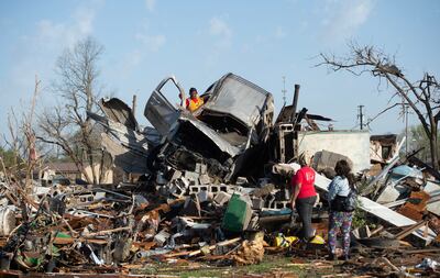 KeUntey Ousley tries to salvage what he can from a car. USA Today Network . Reuters