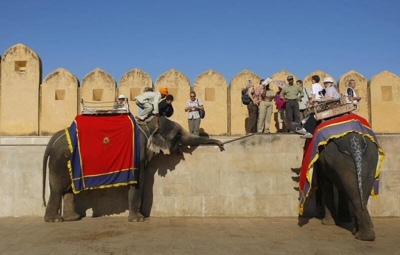 Foreign tourists get off elephants after riding them into the Amber fort near the city in Jaipur. Andrew Caballero-Reynolds / AFP