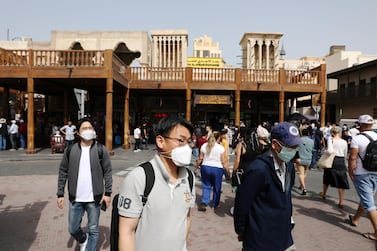 Tourists wear protective face masks as they walk at the Grand Souq in old Dubai. Courtesy: Reuters