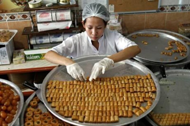 Dubai, August 29, 2011 - Mericres Israel arranges baklava on a tray in Firas Sweets in Dubai, August 29, 2011. (Jeff Topping/The National) 