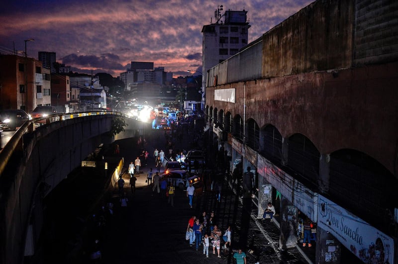 People are seen in the streets of Petare neighbourhood after Caracas and other parts of Venezuela were hit by a massive power cut on July 22, 2019. The lights went out in most of Caracas causing traffic jams and sending people back home on foot after the metro stopped running, while people in other parts of the country took to social media to report the power had gone out there too. The state-owned power company CORPOELEC only reported a breakdown affecting sectors of Caracas. / AFP / Matias DELACROIX
