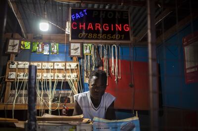 A vendor waits for customers at a charging and telcom kiosk, powered by solar energy, in the Kiryandongo Refugee Settlement in Bweyale, Uganda, on February 25, 2022. Bloomberg