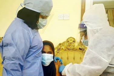 A domestic worker receives the Sinopharm vaccine as part of a home vaccination programme in Sharjah. Salam Al Amir / The National