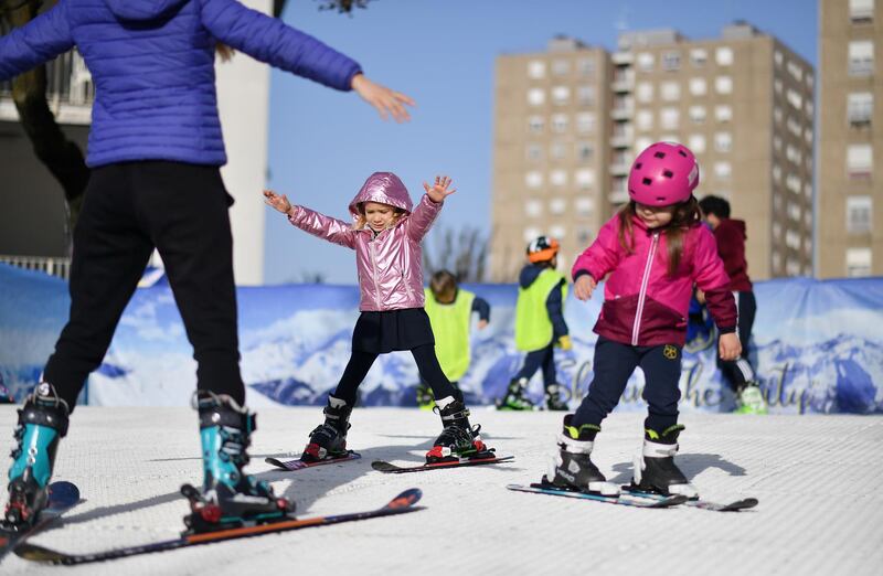 School children ski with help of their instructor at a makeshift ski slope constructed at a school courtyard, as ski instructors get creative during ski resort closures in Milan, Italy. Reuters