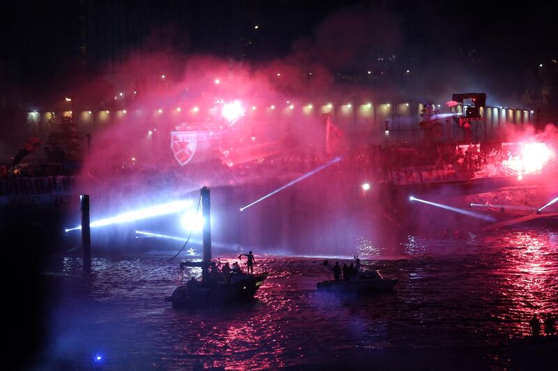 Supporters light flares on the bank of the Sava river after the Red Star Belgrade won the SuperLiga. AFP