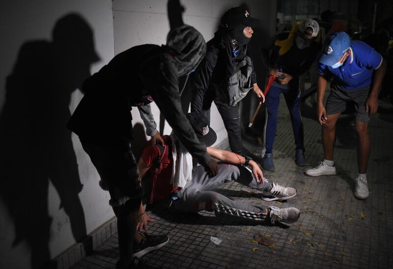 Demonstrators attend to an injured fellow demonstrator during a protest outside the Estadio Olimpico Romelio Martinez. Reuters