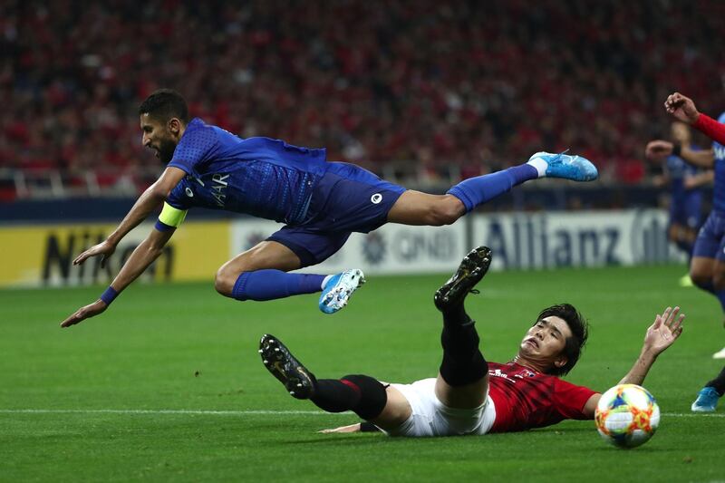 Al Hilal's Salman Al Faraj (top) falls after a challenge by Urawa's Takuya Iwanami. AFP