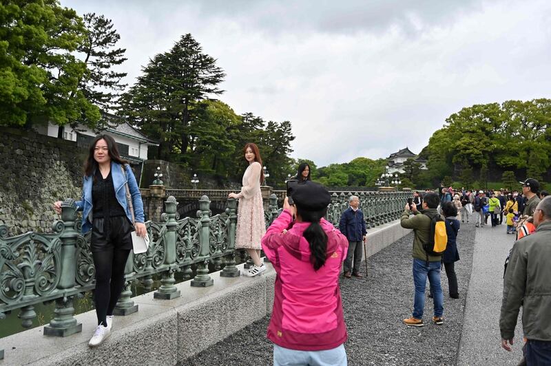 People take pictures near the Double Bridges at the Imperial Palace in Tokyo. AFP