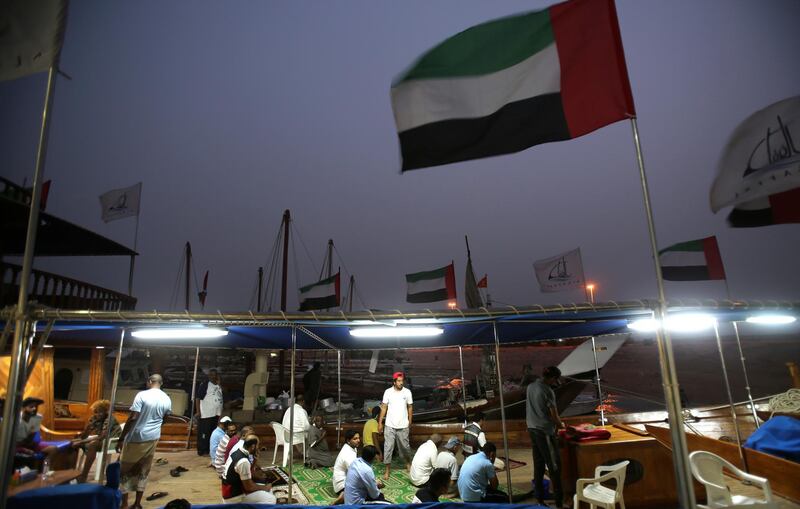 Ssailors socialise after their evening prayer a day ahead of the Al Gaffal traditional Dhow Race. Kamran Jebreili / AP Photo