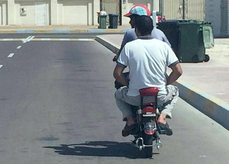 The Ministry of Interior’s security media department captured this image of a rider and his passenger. Neither are wearing helmets. They are wearing sandals and the passenger is not holding on to the side grips. The turn indicator lights appear to be missing and the rear tyre under inflated. Courtesy Security Media 