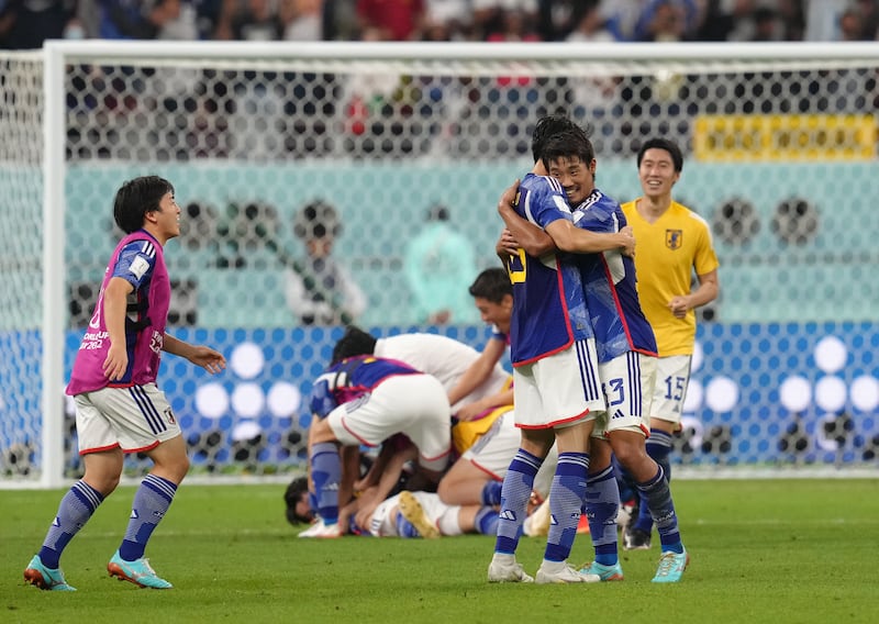 Japan's Hidemasa Morita celebrates with teammates at the final whistle. PA