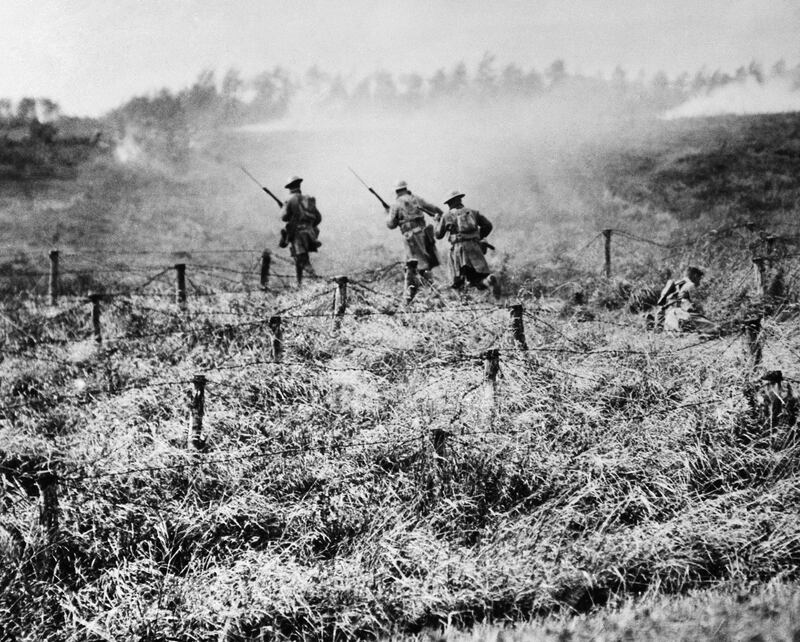 US troops advance on a path through a barbed wire entanglement near Beauqueanes, Somme, France.