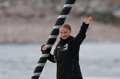 Swedish climate activist Greta Thunberg waves from aboard the Malizia II IMOCA class sailing yacht off the coast of Plymouth, southwest England, on August 14, 2019, as she starts her journey across the Atlantic to New York where she will attend the UN Climate Action Summit next month. A year after her school strike made her a figurehead for climate activists, Greta Thunberg believes her uncompromising message about global warming is getting through -- even if action remains thin on the ground. The 16-year-old Swede, who sets sail for New York this week to take her message to the United States, has been a target for abuse but sees that as proof she is having an effect. / AFP / Ben STANSALL
