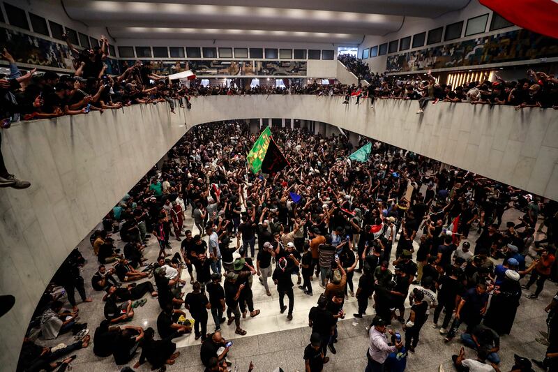 Protesters enter the building after thousands of Sadrists had massed at the end of a bridge leading to Baghdad's Green Zone.  AFP