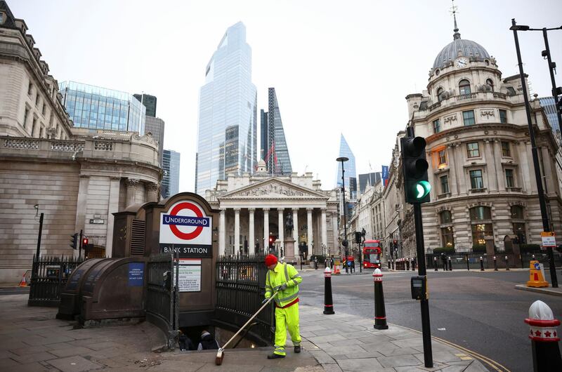 A worker sweeps a pavement at the Bank Junction in London. Reuters