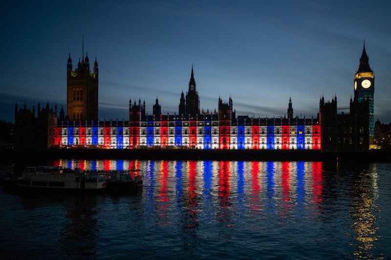 The Palace of Westminster is lit up in red, white and blue during the Coronation of King Charles III and Queen Camilla. Getty