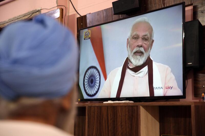 epa08417382 An Indian man listens to Indian Prime Minister Modi's address on TV in Amritsar, India, 12 May 2020. Prime Mnister has said that 4th phase of COVID-19 lockdown will be completely new along with announcing an economic package.  EPA/RAMINDER PAL SINGH