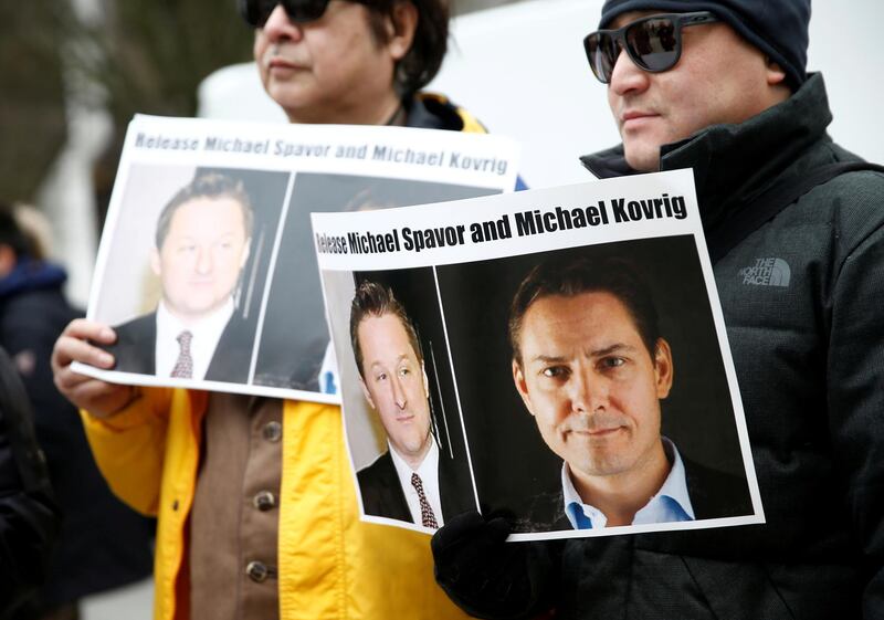 FILE PHOTO: People hold signs calling for China to release Canadian detainees Michael Spavor and Michael Kovrig during an extradition hearing for Huawei Technologies Chief Financial Officer Meng Wanzhou at the B.C. Supreme Court in Vancouver, British Columbia, Canada, March 6, 2019.  REUTERS/Lindsey Wasson/File Photo