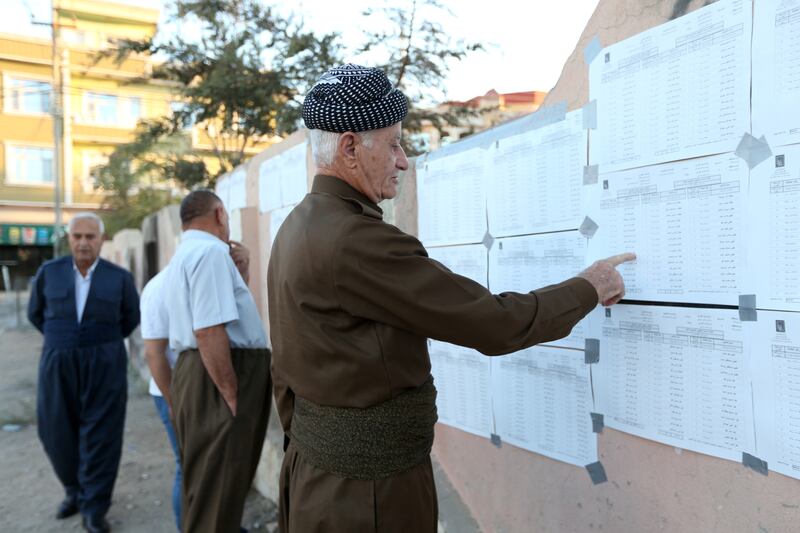 Voters look for their names on a list at a polling station in Duhok. Photo: Reuters