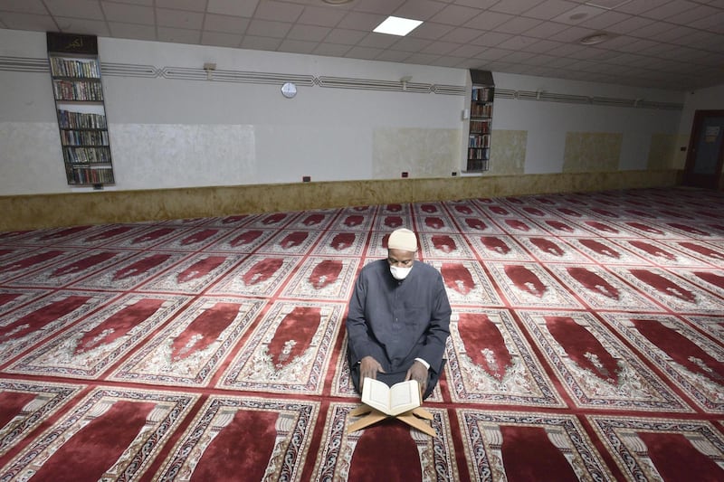 The Imam of the of the Islamic Centre of Bergamo, Boureima Songne, wearing a protective mask, reads Quran amid the coronavirus outbreak on the first day of the holy month in the mosque of Bergamo, Italy, 24 April 2020. EPA