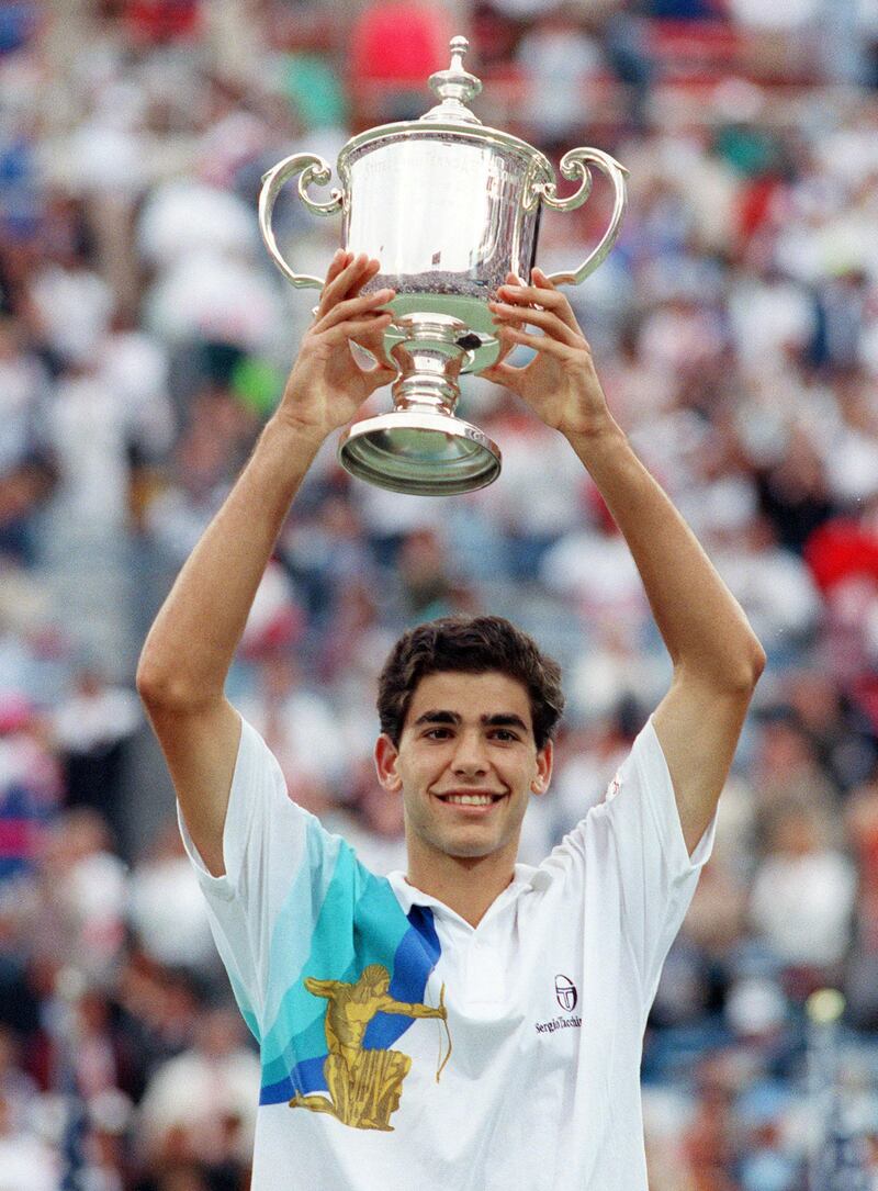 American tennis player Pete Sampras holds the Winner's trophy after defeating compatriot Andre Agassi in the Men's US Open final at Flushing Meadows, here 9 september 1990. (Photo by CAROL NEWSOM / AFP)