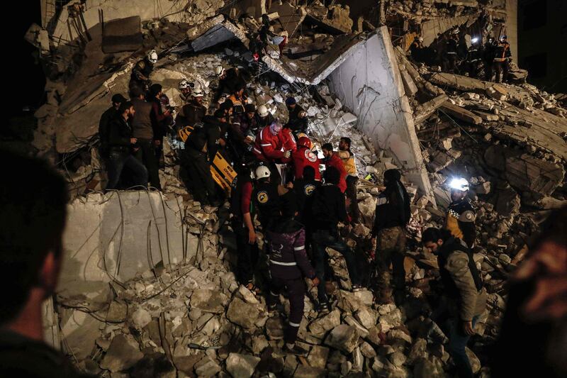 Syrian civil Defence volunteers and Red Crescent members evacuate survivors following an explosion in the rebel-held city of Idlib. Sameer Al-Doumy / AFP