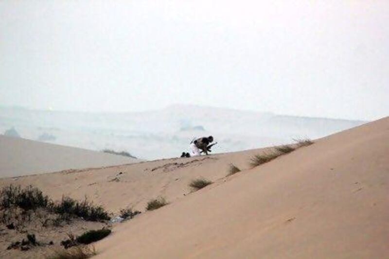 A member of the Egyptian security forces takes position on a sand dune during an operation in the northern Sinai peninsula yesterday. The operation killed 20 militants in the Sinai village of Tumah in retaliation for a weekend ambush that cost the lives of 16 Egyptian soldiers.
