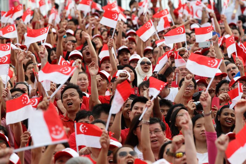 People wave the flags during the National Day Parade at Padang on August 9, 2015 in Singapore. Suhaimi Abdullah / Getty Images