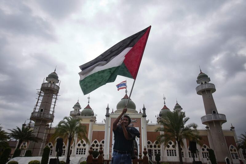 A Thai Muslim man waves a Palestinian flag in front of Pattani Central Mosque in Pattani. Tuwaedaniya Meringing / AFP Photo