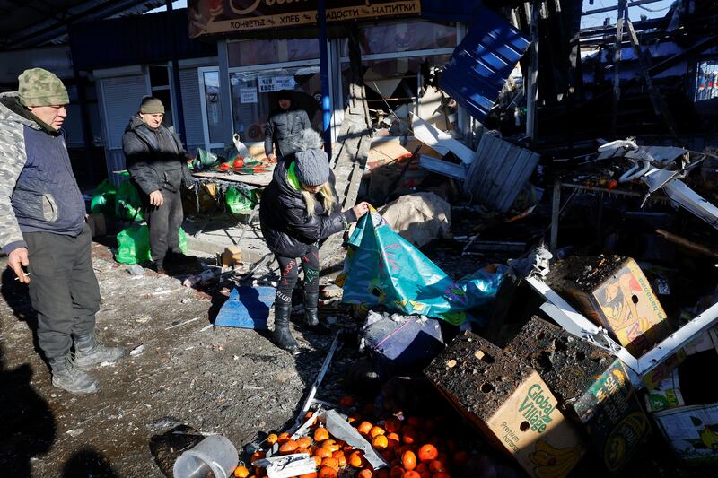 People remove debris at a food market in Donetsk, Ukraine, after what local Russian-installed authorities say was a Ukrainian military strike. Reuters