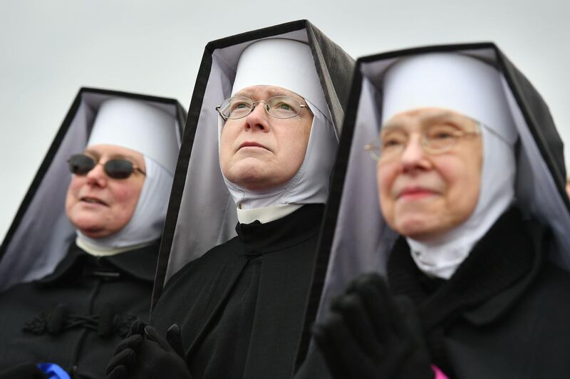 Dominican Sisters of Hartland, Michigan, listen as US President Donald Trump speaks at a "Make America Great Again" rally at Oakland County International Airport.  AFP