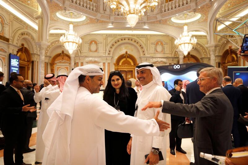 Participants of the Future Investment Initiative forum, "FII", chat during the opening session. AP Photo