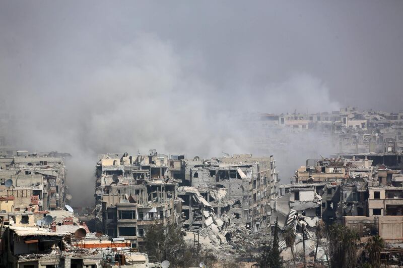 TOPSHOT - Smoke billows following Syrian government bombardment on the rebel-held besieged town of Harasta, in the Eastern Ghouta region on the outskirts of Damascus on March 12, 2018. 
Syrian regime forces cut off the largest town in Eastern Ghouta from the rest of the opposition enclave in a blow to beleaguered rebels defending their last bastion near Damascus. Government troops and allied militia have recaptured half of the besieged region in a blistering assault launched on February 18 that has left nearly 1,000 civilians dead and prompted global outcry. / AFP PHOTO / -