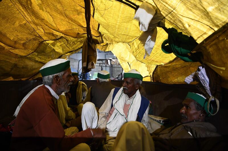 Farmers rest on a tractor trailer near a police road block stopping them from marching to New Delhi to protest against the central government's recent agricultural reforms.  AFP