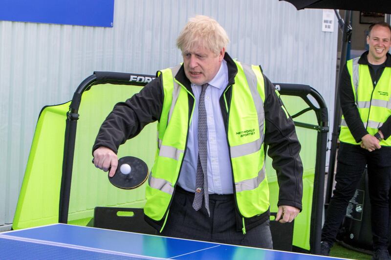 Boris Johnson plays table tennis during the visit. Reuters
