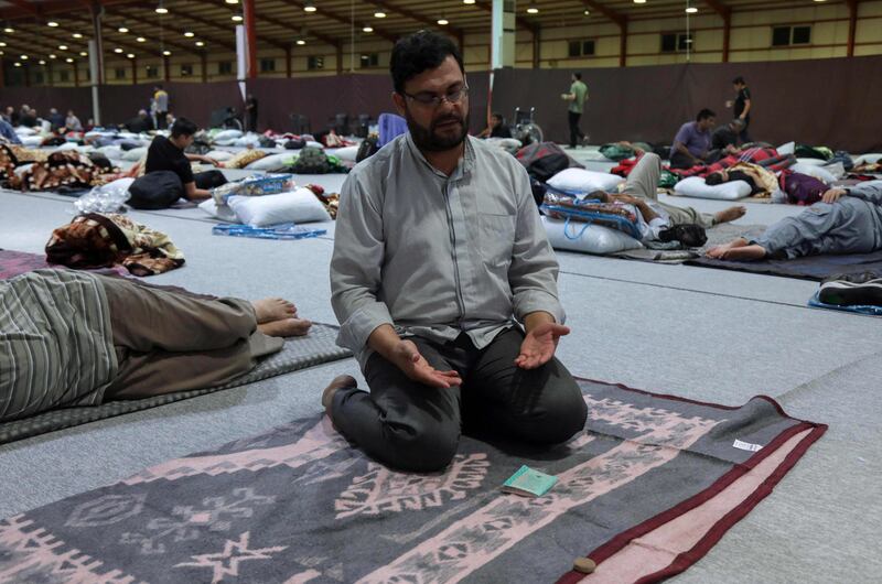 An Iranian pilgrim prays as others rest in Arbil, the capital of Iraq's autonomous Kurdish region, before continuing their journey towards Karbala. AFP
