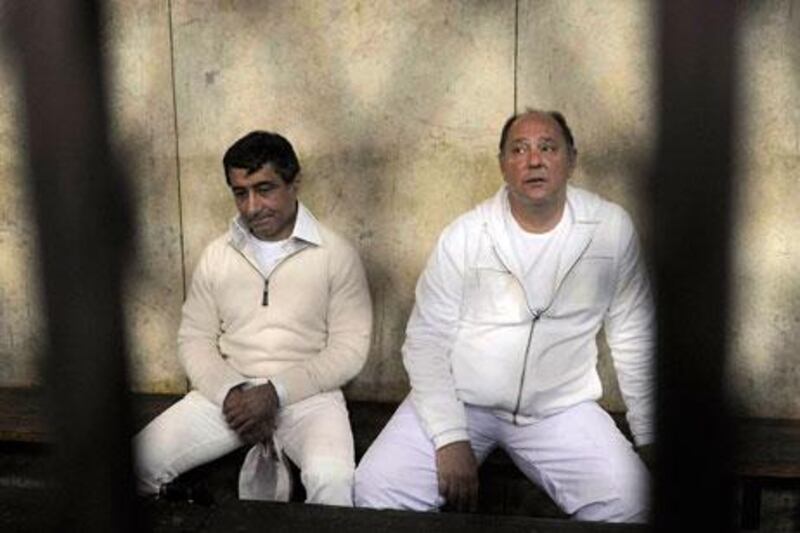 Ahmed Ezz, a steel tycoon, left, and the former Egyptian tourism minister, Zuheir Garana, sit in the Cairo Criminal Court in 2011. On Wednesday, Ezz was sentenced to 37 years in prison for profiteering. AP Photo