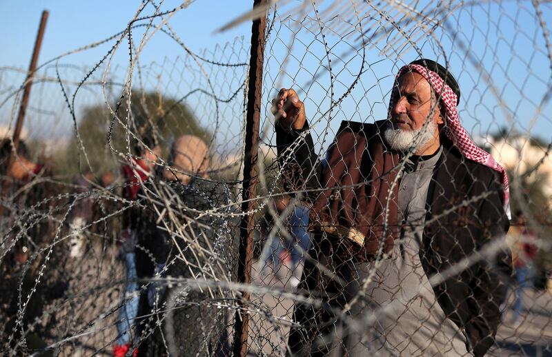 A Palestinian man stands by a fence as he waits for a travel permit to leave Gaza through Rafah border crossing with Egypt, in Rafah in the southern Gaza Strip. Reuters