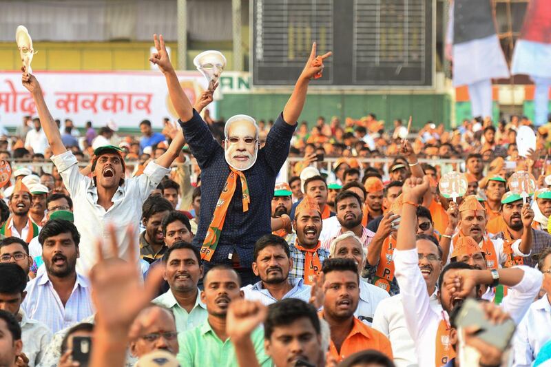 Indian supporters of the Bharatiya Janata Party (BJP) shout slogans as they attend a metting of Prime Minister Narendra Modi political campaign ahead of the forthcoming national elections, in Hyderabad on April 1, 2019. India is holding a general election to be held over nearly six weeks starting on April 11, when hundreds of millions of voters will cast ballots in the world's biggest democracy. / AFP / NOAH SEELAM
