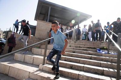 A Palestinian child runs from police deployed for a news conference by Israeli right-wing lawmaker Itamar Ben Gvir at the Damascus Gate to Jerusalem's Old City, where he protested police preventing him from entering the Al Aqsa Mosque compound, Thursday, June 10, 2021.  (AP Photo/Maya Alleruzzo)