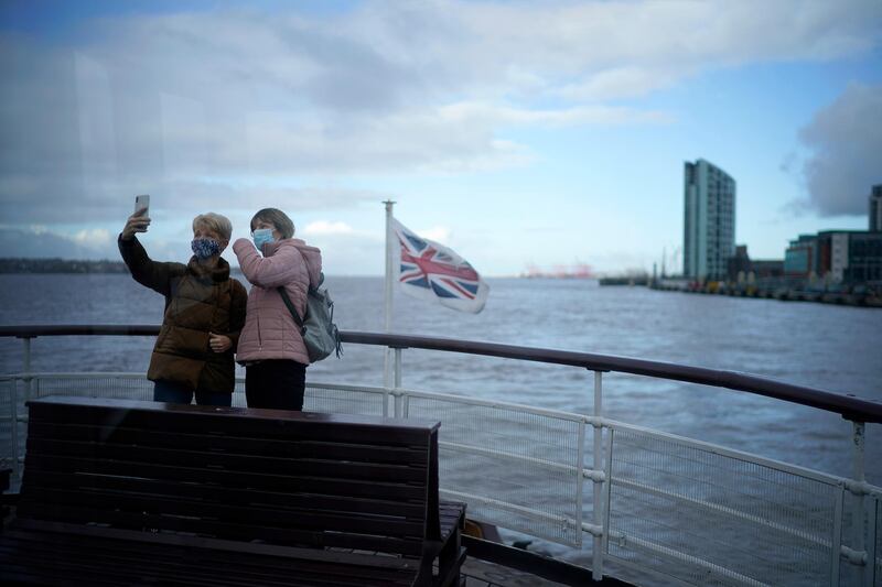 Passengers on the Mersey Ferry take a selfie photo in Liverpool, England. Getty Images