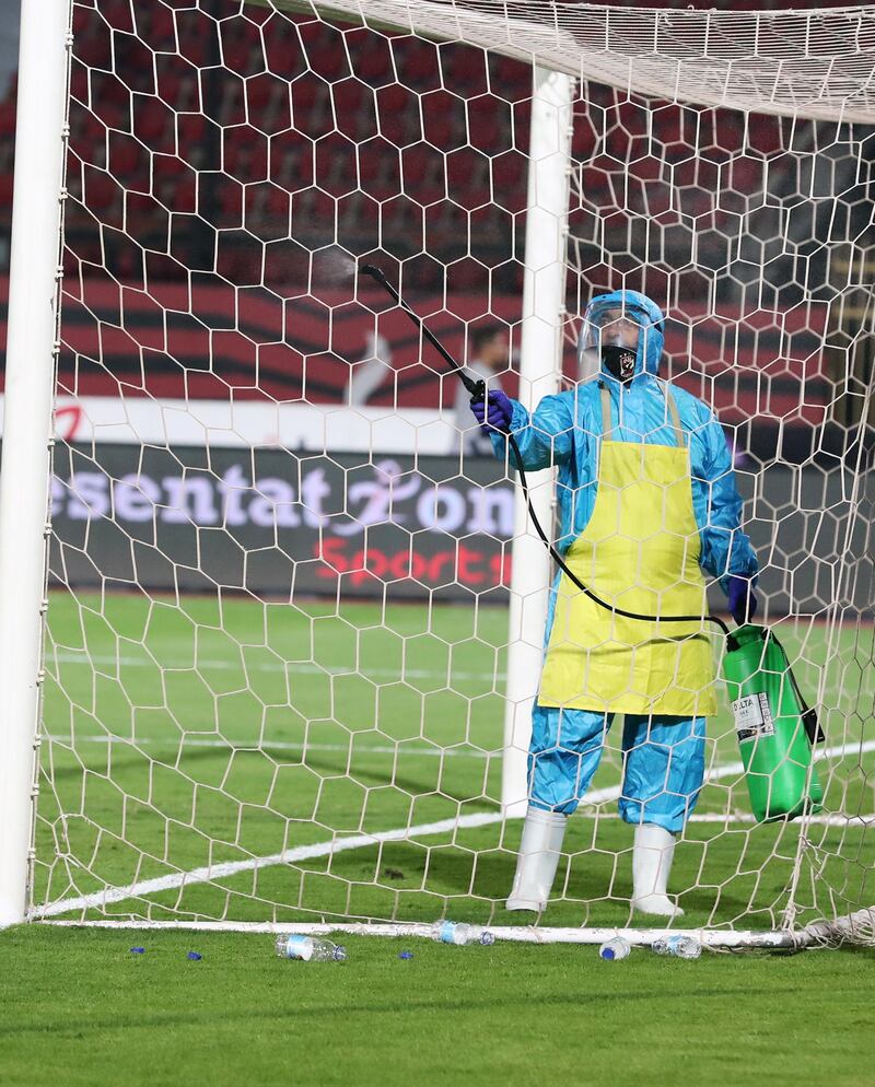 Stadium staff member disinfects the goal  during the Egyptian Premier League soccer match between Al-Ahly and Enppi at Salam Stadium in Cairo, Egypt. EPA